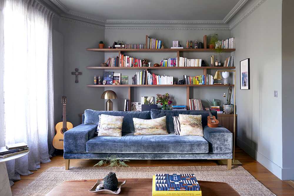 Salon et bibliothèque avec un canapé en velours bleu